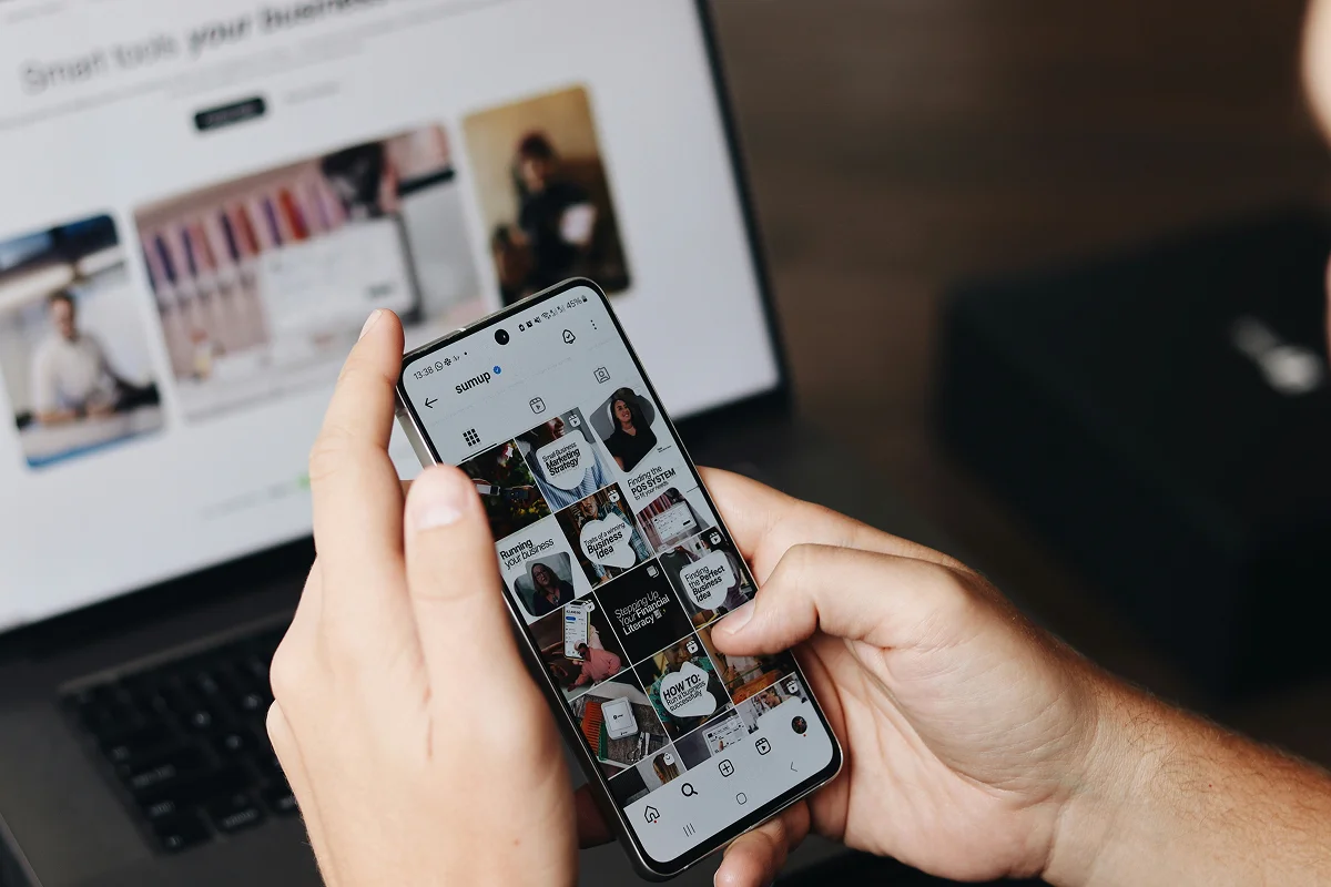 Marketer scrolling social media on phone — brand vs demand balance