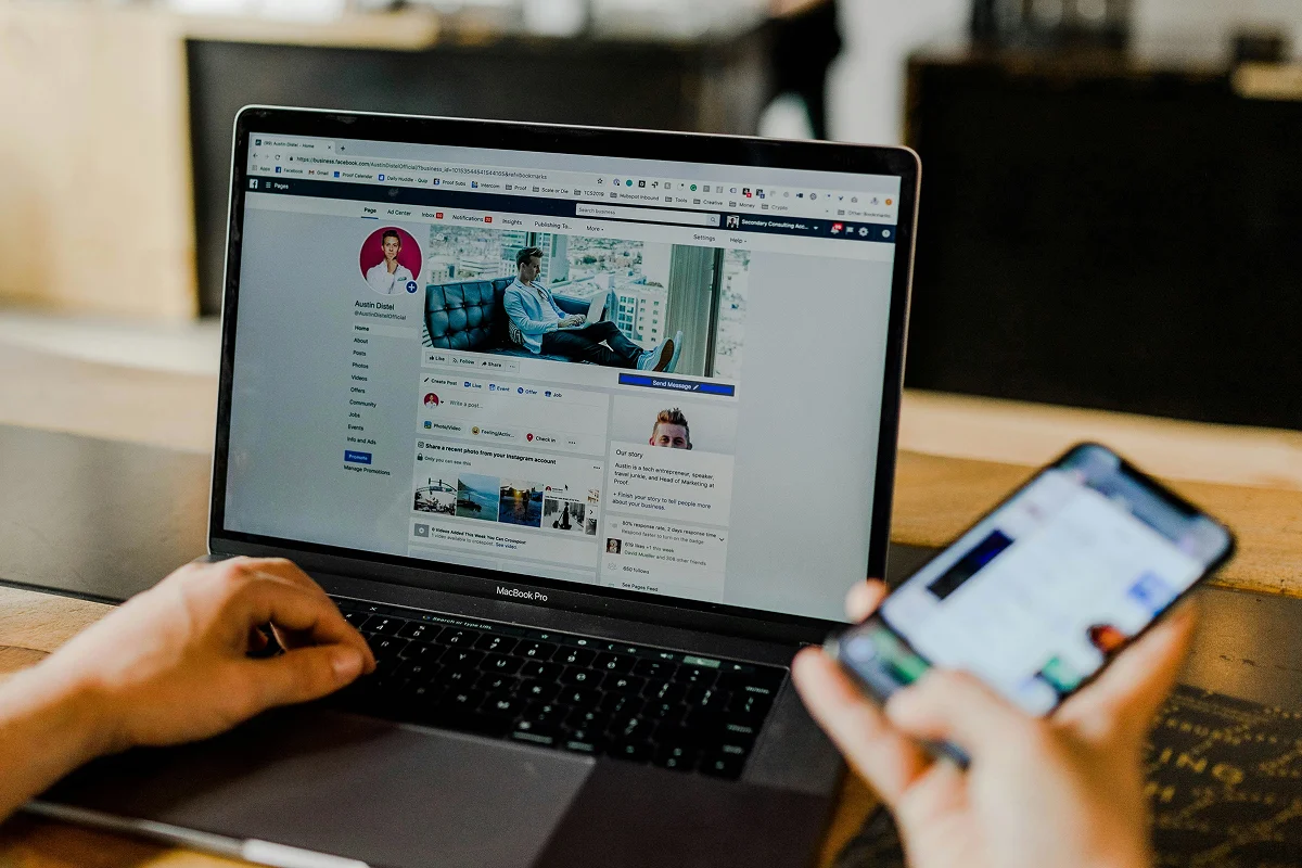 Marketer managing LinkedIn profile on laptop and phone